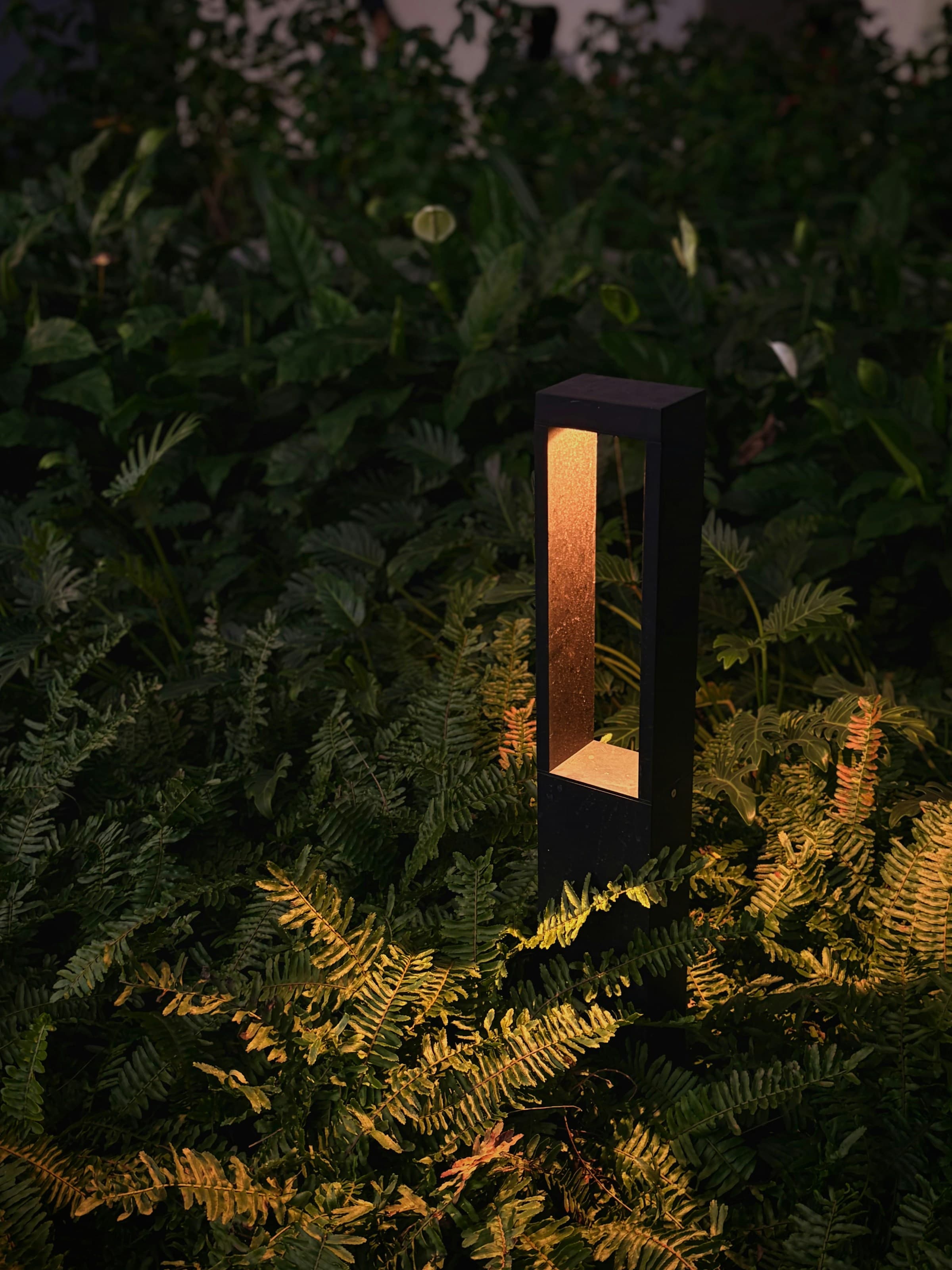 Borne lumineuse éclairant les plantations de la terrasse au crépuscule